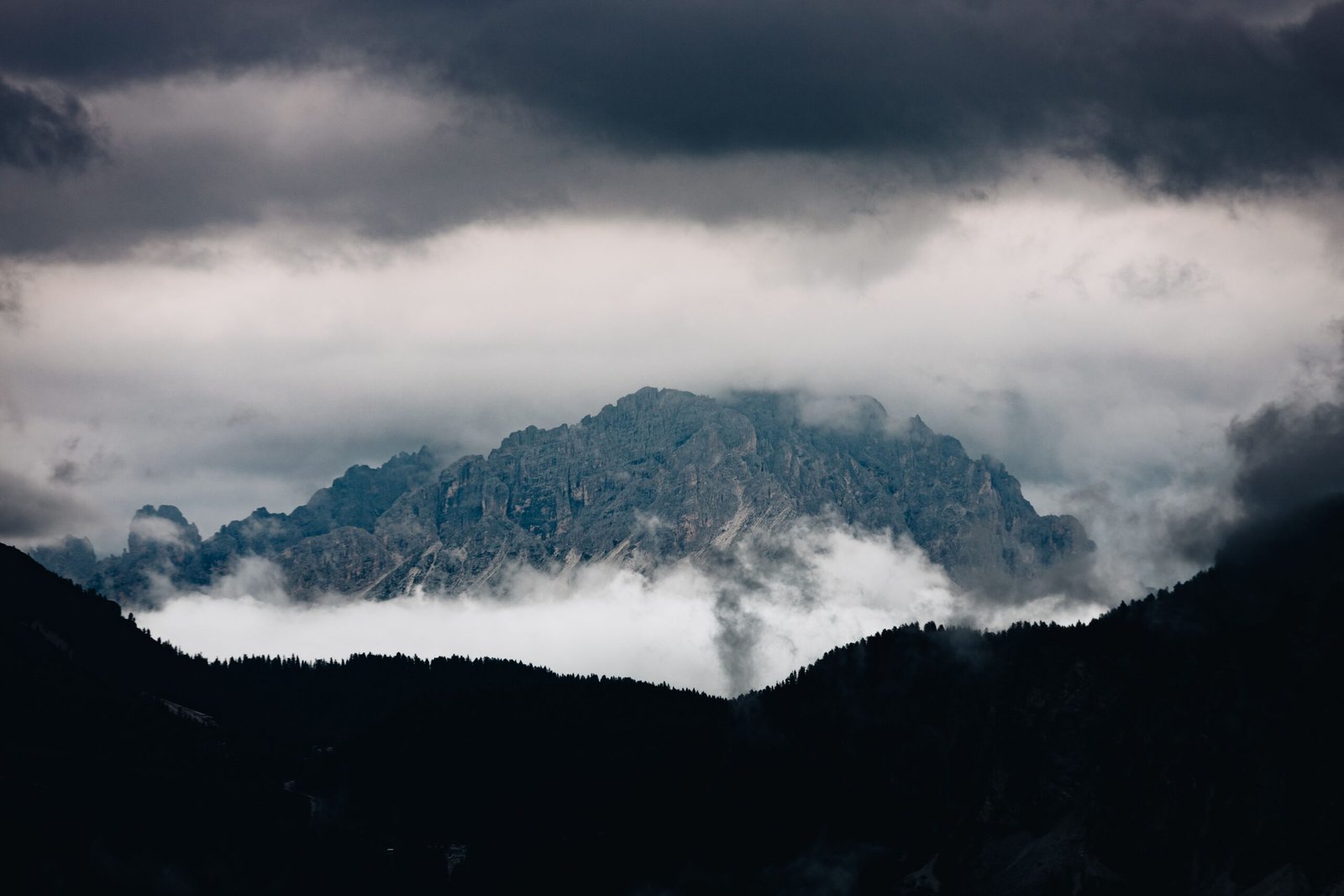 A scenic mountain peak partially obscured by clouds creates a dramatic natural landscape.